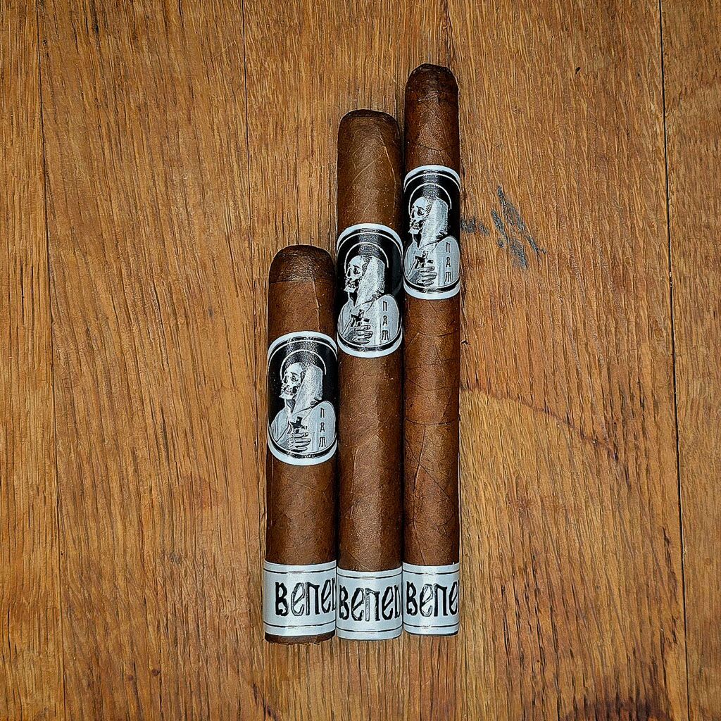 BLTC Benediction Robusto, Lonsdale, and Toro cigars displayed in graduated size order on rustic wood surface showing Nicaraguan Habano wrapper and white Benediction band at Smokers Abbey Austin
