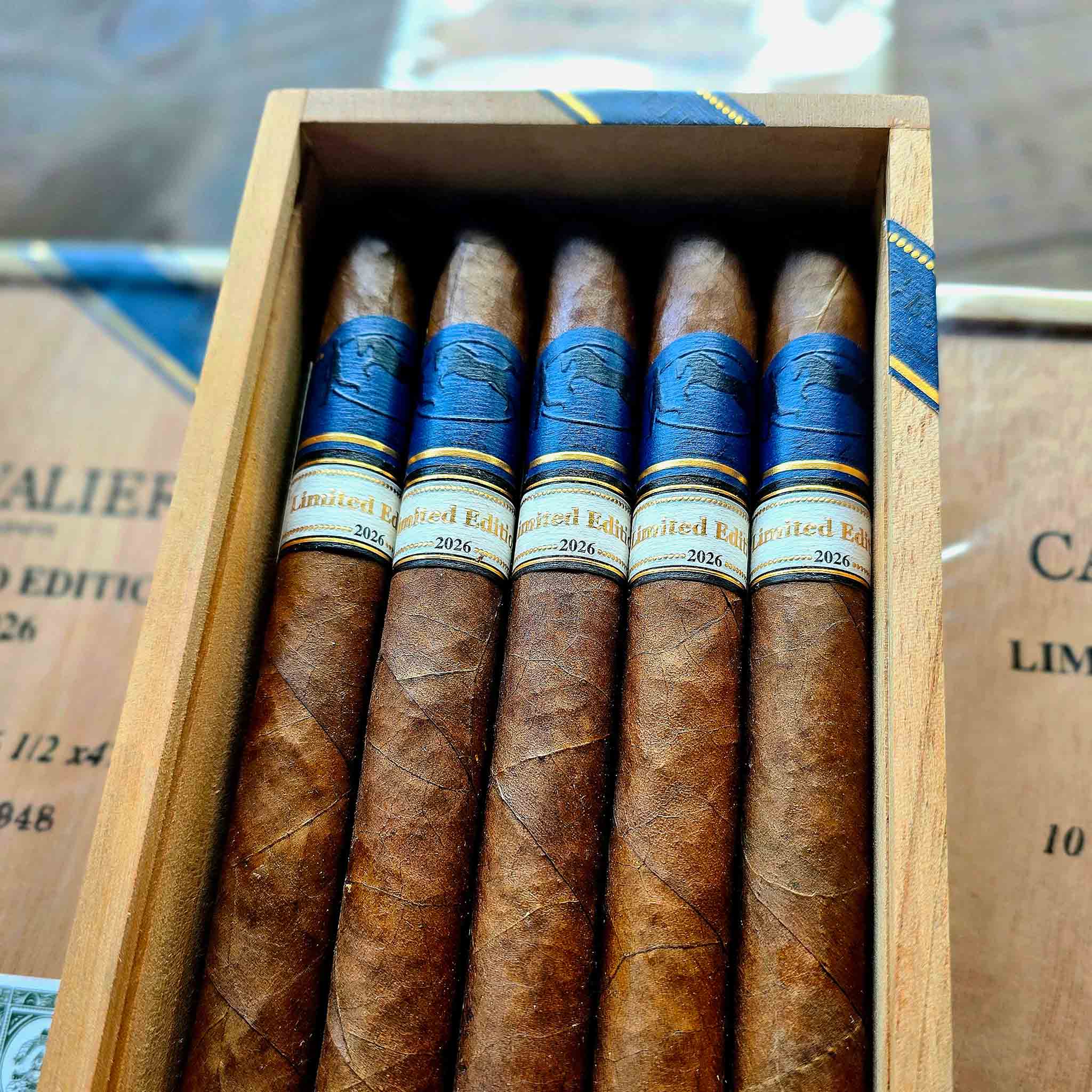 Cavalier Genève Limited Edition 2026 cigars with blue Cavalier band and ivory Limited Edition 2026 band standing in an open wooden box at Smokers Abbey Austin