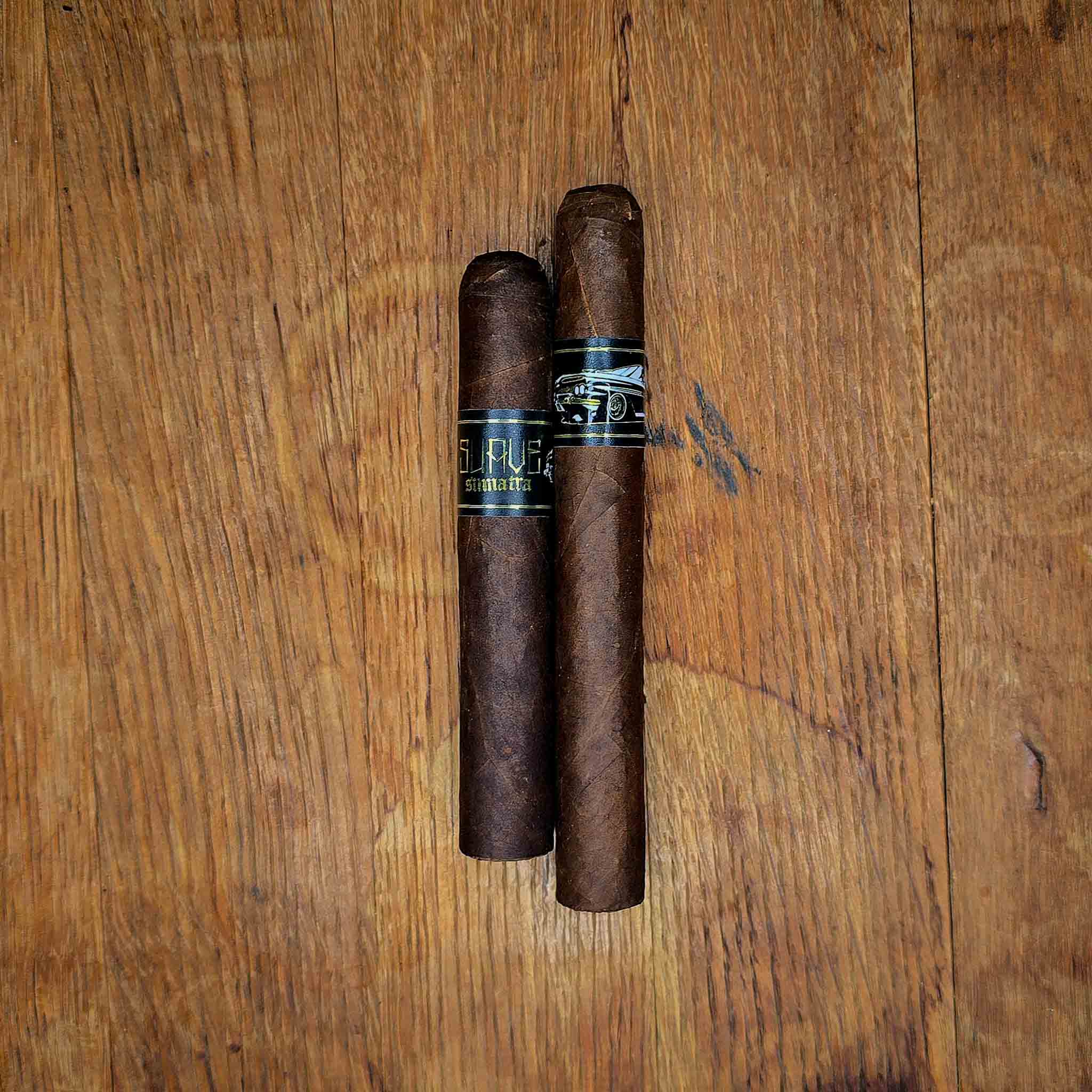 Emilio Suave Sumatra Robusto and Toro cigars with black and gold Suave band displayed side by side on rustic wood surface at Smokers Abbey Austin