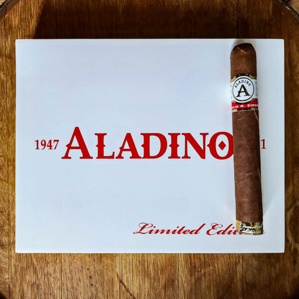 A JRE Aladino Limited Edition Toro cigar resting on a white Aladino Limited Edition box lid with red Aladino branding.