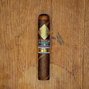 A Cavalier Genève Prospektor Limited Release 2025 barber pole cigar displayed on a wooden surface, featuring the gold diamond logo and Limited Release band.