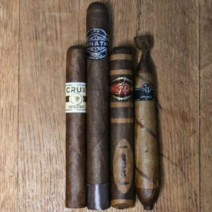 Crux Epicure Habano Toro, JFR Lunatic Maduro 8x60, LFD Exclusive Football cigar, and Jake Wyatt Fourth Dimension Figurado on wooden table