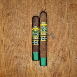 Casa Carrillo Allegiance Sidekick and Confidant box pressed cigars with green and gold band and green footer displayed side by side on rustic wood surface at Smokers Abbey Austin