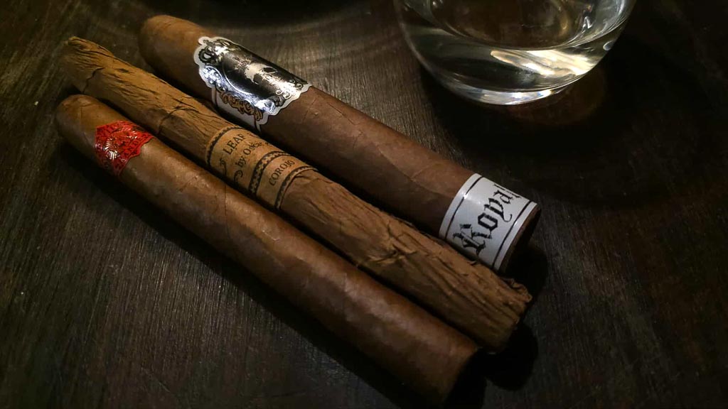 Corojo cigars lineup including Leaf by Oscar and Black Label Trading Co with a glass of wine