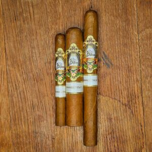 Three La Galera Connecticut cigars in Cepo, Pilone, and Presidente vitolas displayed side by side on rustic wood surface showing Ecuadorian Connecticut wrapper and ornate gold La Galera band at Smokers Abbey Austin