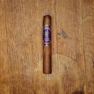 Chateau Diadem Splendor Robusto Extra cigar with purple and gold band displayed on rustic wood surface at Smokers Abbey Austin