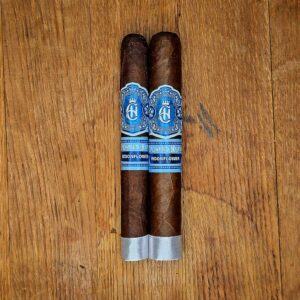 Crowned Heads Moonflower Corona Gorda and Toro cigars displayed side by side on rustic wood surface showing dark Nicaraguan Corojo wrapper and blue and silver Moonflower band at Smokers Abbey Austin Caption: