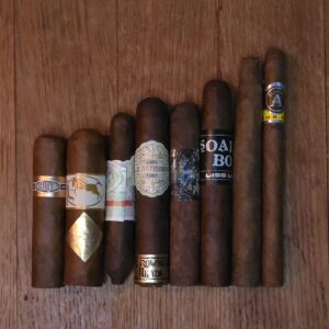 Short Format No. 1 cigar sampler featuring Curivari Buenaventura, Cavalier White Series, La Instructora No. 2, Crowned Heads La Patissier, La Instructora Box Pressed, Dissident Soapbox, La Galera Imperial Jade Chiquito Perfecto, and Aladino Corojo Santi displayed on rustic wood surface at Smokers Abbey Austin