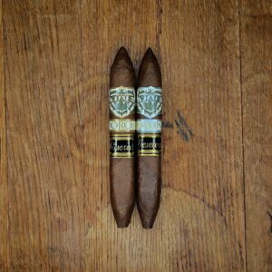 Viaje Perfecto Reserva Oro and Platino cigars displayed side by side on rustic wood surface at Smokers Abbey Austin