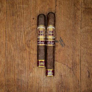 Casa Carrillo Ascend Saddle and Ridge box pressed cigars with ivory and maroon band displayed side by side on rustic wood surface at Smokers Abbey Austin